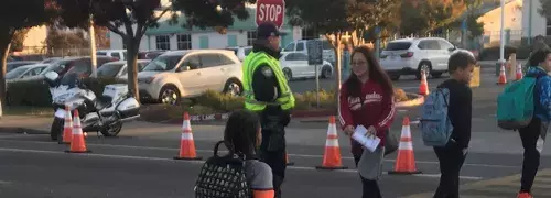 police officer helping children cross street